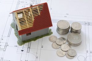 a miniature of a house and coins